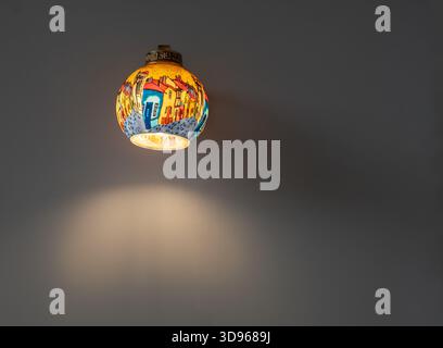 Vintage-BH mit Hintergrundbeleuchtung an einer Steinwand. Farbenfrohe, handgefertigte Lampe oder Wandleuchte an der Wand in einem Haus. Eine künstliche Lichtlampe. Goa Indien - Juli 4,2 Stockfoto