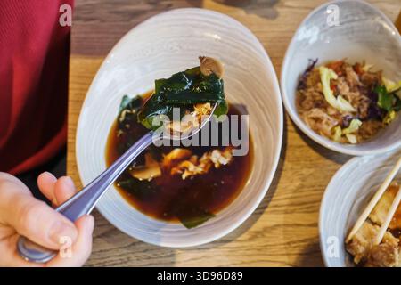 Person genießt eine Schüssel mit traditioneller japanischer Miso-Suppe mit Zutaten Stockfoto