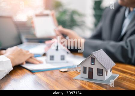 Erklären und präsentieren Sie Informationen über Immobilienkäufe und Hypothekenkäufe. Immobilienmakler bieten Immobilien im Projekt an, um sie den Kunden ausführlich zu erklären. Steuern Stockfoto