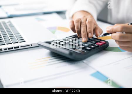 Geschäftsfrau händigt Finanzen aus und berechnet am Schreibtisch die Kosten im Home Office. Business Finance Accounting Banking Konzept. Frau, die an des arbeitet Stockfoto
