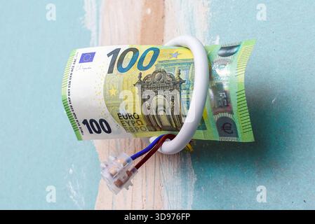 Elektroinstallation für die Renovierung der Beleuchtung, 100 Euro Papierschein hängt an Drähten in einer alten Wohnung, Renovierung der Beleuchtung von Wohnwohnungen mit Stockfoto