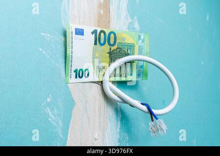 Elektroinstallation für die Renovierung der Beleuchtung, 100 Euro Papierschein hängt an Drähten in einer alten Wohnung, Renovierung der Beleuchtung von Wohnwohnungen mit Stockfoto
