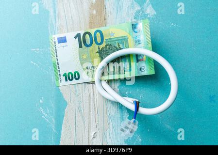 Elektroinstallation für die Renovierung der Beleuchtung, 100 Euro Papierschein hängt an Drähten in einer alten Wohnung, Renovierung der Beleuchtung von Wohnwohnungen mit Stockfoto