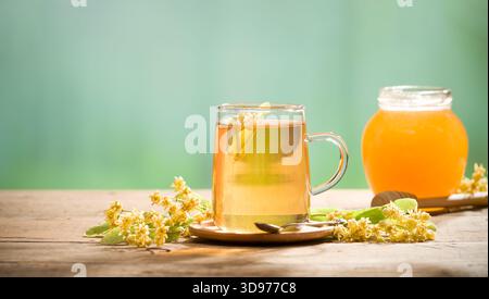 Ein Glas Lindentee. Lindenblumen und Honig im Hintergrund Stockfoto