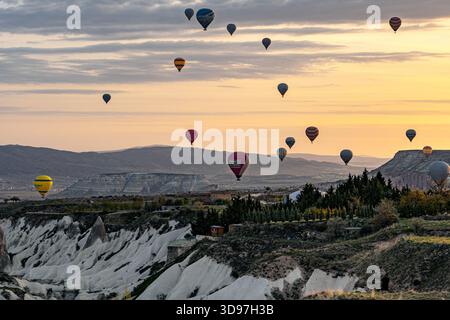 Goreme, Türkei - 19. April 2025: Aus der Vogelperspektive steigen Heißluftballons über die geformten Felsformationen Kappadokiens auf, eine Symphonie voller Schwung Stockfoto