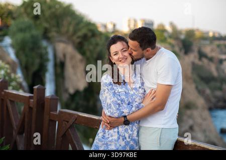 Ein romantisches Paar genießt einen gemeinsamen Moment in der Nähe des wunderschönen Wasserfalls und fängt einen unvergesslichen Tag im Freien an einem malerischen Ort ein Stockfoto