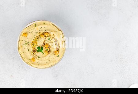 Lupin hummus in weißer Schüssel mit Petersilie auf weißem Hintergrund. Veganes Essen. Draufsicht. Kopierbereich. Stockfoto