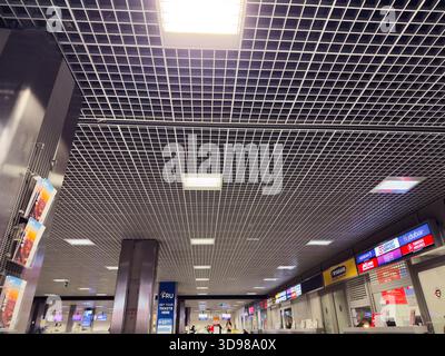 Krakau, Polen - 07. November 2025: Passagiere bewegen sich durch ein modernes polnisches Flughafenterminal mit Schildern und Serviceschaltern. Stockfoto