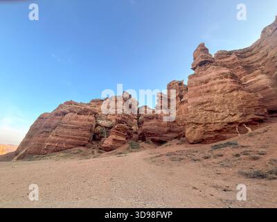 Flacher Blick auf die Felsformationen des Charyn Canyon: Geschichteter Stein, wilde Natur Kasachstans unter blauem Himmel. Stockfoto