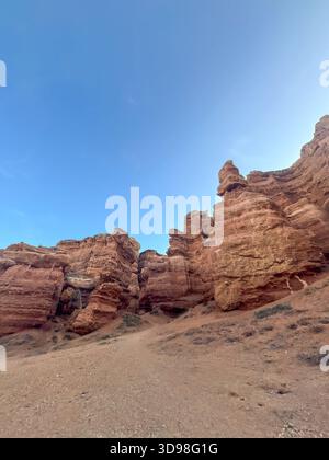 Flacher Blick auf die Felsformationen des Charyn Canyon: Geschichteter Stein, wilde Natur Kasachstans unter blauem Himmel. Stockfoto