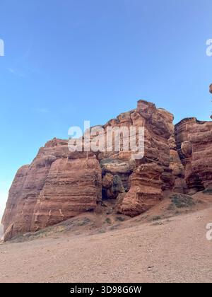 Flacher Blick auf die Felsformationen des Charyn Canyon: Geschichteter Stein, wilde Natur Kasachstans unter blauem Himmel. Stockfoto