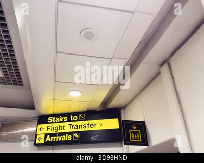 Manchester, Großbritannien - 07. November 2025: Die Beschilderung zum Flughafen weist Reisende mit hellgelbem Kontrast zum Transfer und zur Ankunft an. Stockfoto
