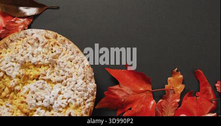 Mit rundem, mit Zucker bestäubtem Gebäck auf Holzkohleplatte, roten Orangenblättern Stockfoto