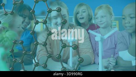 Kinder und Pädagogen am Klassentisch sammeln, Windturbinen und Molekularmodell untersuchen Stockfoto