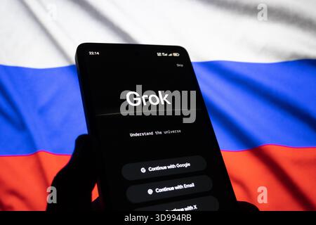 GROK-Bildschirm auf Smartphone-Monitor mit russischer Flagge. Das redaktionelle Foto wurde aufgenommen: Baku, Aserbaidschan. 29.11.2025. Stockfoto