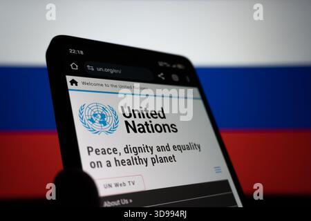 Homepage der Vereinten Nationen auf dem Smartphone-Bildschirm mit russischer Flagge. Das redaktionelle Foto wurde aufgenommen: Baku, Aserbaidschan. 29.11.2025. Stockfoto