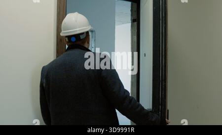 Architekt oder Ingenieur, der in einen Raum auf einer Baustelle geht und einsatzbereit ist Stockfoto