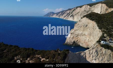Blick aus der Vogelperspektive auf die Klippen und das wunderschöne blaue Meer mit grünen Pflanzen auf der Spitze Stockfoto