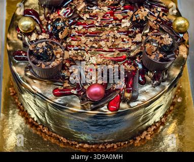 Luxuriöser goldener Schokoladenfeierungstorte mit Metallic-Finish und Gourmet-Dekor für besondere Anlässe. Süßigkeiten Hintergrund Stockfoto