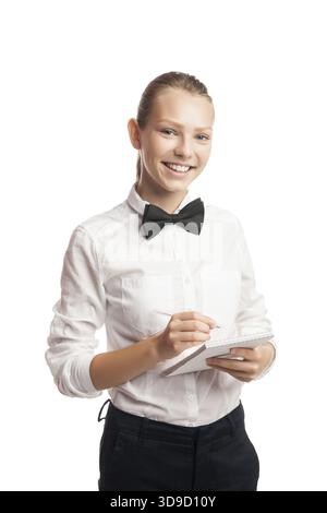 Porträt einer fröhlichen Kellnerin in Uniform, die Ordnung beim Blick auf die Kamera aufnimmt. Studio-Aufnahme Stockfoto