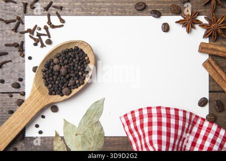 Papier für Rezepte, Pfeffer und Gewürze auf Holztisch Stockfoto