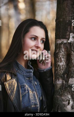 Mädchen eine Brünette mit dem Handy im park Stockfoto