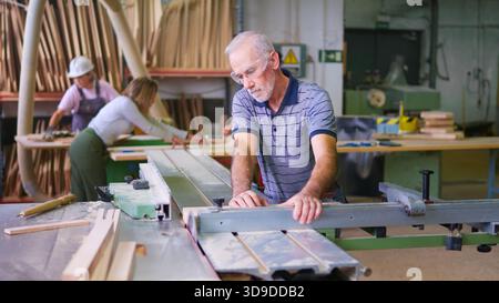 Zimmermann schneidet Holz auf einer Tischsäge in der Werkstatt Stockfoto