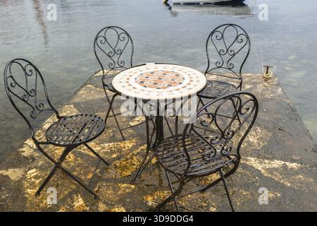 Typische istrische Architektur: Meer, Mauern, Häuser, Fenster, Steine und Straßen von Porec in Kroatien. Stühle und Tisch am Meer Stockfoto