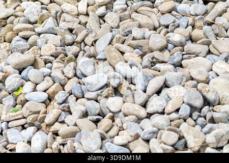 Glatte Kiessteine in verschiedenen Formen und Größen schaffen eine strukturierte Oberfläche im Außenbereich. Stockfoto