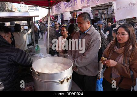 Kunden stehen an, um Yomari zu kaufen, ein traditionelles nepalesisches Süßes. Kathmandu, Nepal, 4. Dezember 2025. Am 4. Dezember 2025 feierten die Menschen das traditionelle Yomari Punhi Festival mit Paraden und Versammlungen in Kathmandu, Nepal. Quelle: Cui Nan/China News Service/Alamy Live News Stockfoto