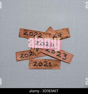 Dieses Foto zeigt jährliche Etiketten von 2020 bis 2026, die Fortschritt, Übergang, Reflexion und Erwartung symbolisieren, während die hellen 2026-Tag-Highlights hervorgehoben werden Stockfoto