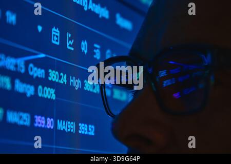 Börsenstatistiken und Finanzdaten aus der Sicht des Händlers, die sich in einer Brille widerspiegeln Stockfoto