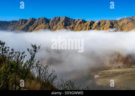 Wolken bedecken die Berge am frühen Morgen. Los Cardones Nationalpark, Salta, Argentinien. Stockfoto