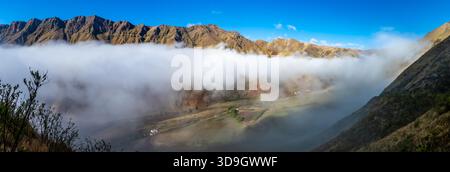Wolken bedecken die Berge am frühen Morgen. Los Cardones Nationalpark, Salta, Argentinien. Stockfoto