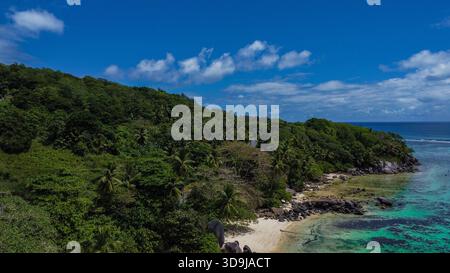 Abgeschiedener tropischer Strand, Sandy Cove und üppiges Green Forest Headland mit klarem türkisfarbenem Wasser Stockfoto