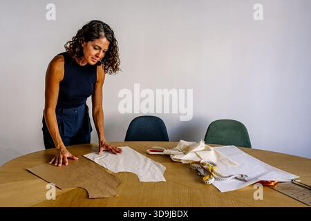 Weibliche Modedesignerin kreiert ein neues Musterstück auf dem Tisch Stockfoto