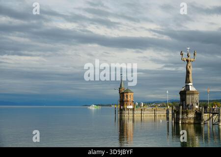 Die berühmte satirische Imperia-Statue von Peter Lenk an der Hafeneinfahrt von Konstanz am Bodensee unter dramatischem Himmel. Stockfoto