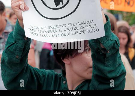 Der Demonstrant hält ein Zeichen gegen Diskriminierung während einer Menschenrechtsdemonstration in einer überfüllten Straße. Stockfoto