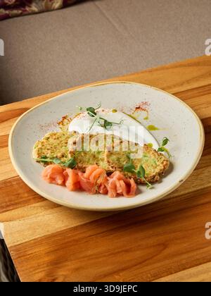 Köstliche Frühstückspräsentation, ansprechender Frühstücksteller am Wochenende mit Räucherlachs und lebhaften Beilagen Stockfoto