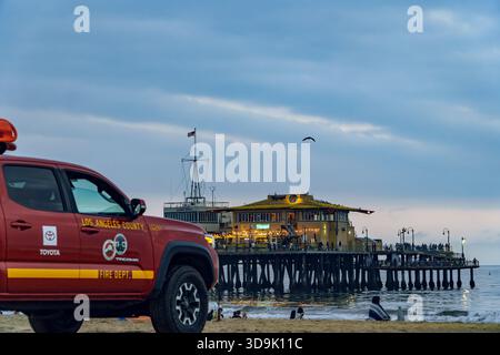 Santa Monica, CA, USA. September 2025. - Ein Rettungswagen der Feuerwehr von Los Angeles, der am Strand parkt, während sich die Leute entspannen und sich auf einem i versammeln Stockfoto
