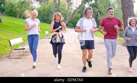 Eine Gruppe älterer Freunde läuft zusammen in einem Park Stockfoto