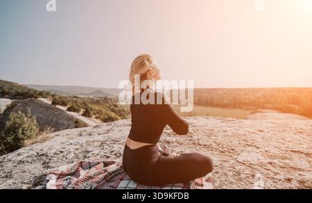 Frau, die Yoga auf einem Berggipfel praktiziert Stockfoto