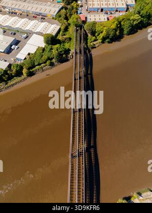 Blaydon on Tyne UK: 15. August 2025: Alte Eisenbahnbrücke in Richtung Blaydon Industrial Estate, mit verschiedenen Lagerhäusern und Gewerbeeinheiten inmitten von Gree Stockfoto