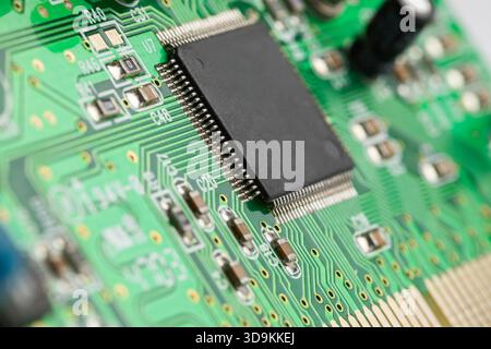 Nahaufnahme eines quadratischen Siliziumchips auf einer grünen Leiterplatte. Der Chip hat Kopierraum. Stockfoto