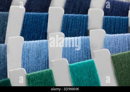 Nahaufnahme von Garnproben in verschiedenen Farben wie Marineblau, Dunkelblau, Hellblau und verschiedenen Grüntönen. Stockfoto