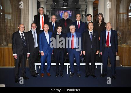 Die Nobelpreisträger von 2025 posieren für ein Gruppenfoto vor der Unterzeichnung der Nobelstühle im Nobelmuseum in Stockholm, Schweden, am 6. Dezember 2025. Obere Reihe von links: John M. Martinis (Physik), Michel H. Devoret (Physik), László Krasznahorkai (Literatur), Omar M. Yaghi (Chemie), Shimon Sakaguchi (Medizin), Mary E. Brunkow (Medizin). Untere Reihe von links: Richard Robson (Chemie), Fred Ramsdell (Medizin), Peter Howitt (Wirtschaft), Philippe Aghion (Wirtschaft), Joel Mokyr (Wirtschaft), Susumu Kitagawa (Chemie), John Clarke (Physik). Foto: Claudio Bresciani/TT/Code 10090 This Stockfoto
