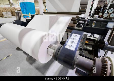 Papierrollen werden tagsüber in einer großen Produktionsstätte verarbeitet Stockfoto