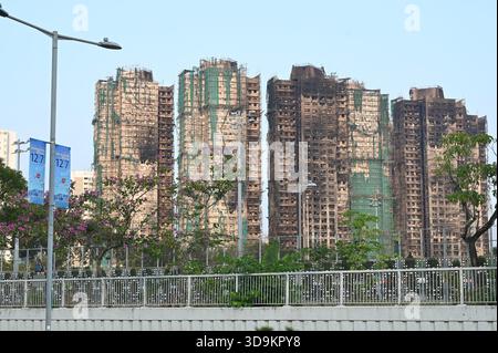 Hongkong, Hongkong. Dezember 2025. Eine Werbung für die Parlamentswahlen des Legislative Council 2025 und den Wohnkomplex des Wang Fuk Court in Tai Po nach einem tödlichen Brand am 6. Dezember 2025 in Hongkong. (Foto: Stringer/Nexpher Images/SIPA USA) Credit: SIPA USA/Alamy Live News Stockfoto