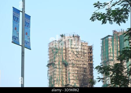 Hongkong, Hongkong. Dezember 2025. Eine Werbung für die Parlamentswahlen des Legislative Council 2025 und den Wohnkomplex des Wang Fuk Court in Tai Po nach einem tödlichen Brand am 6. Dezember 2025 in Hongkong. (Foto: Stringer/Nexpher Images/SIPA USA) Credit: SIPA USA/Alamy Live News Stockfoto