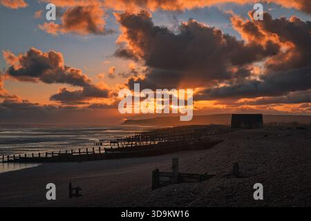 Der Sonnenuntergang im Rye Harbour im Dezember bei Ebbe mit dem Mary Stanford Leuchtturm und der Klippe endet im Hintergrund. An der östlichen Küste von sussex südöstlich eng Stockfoto